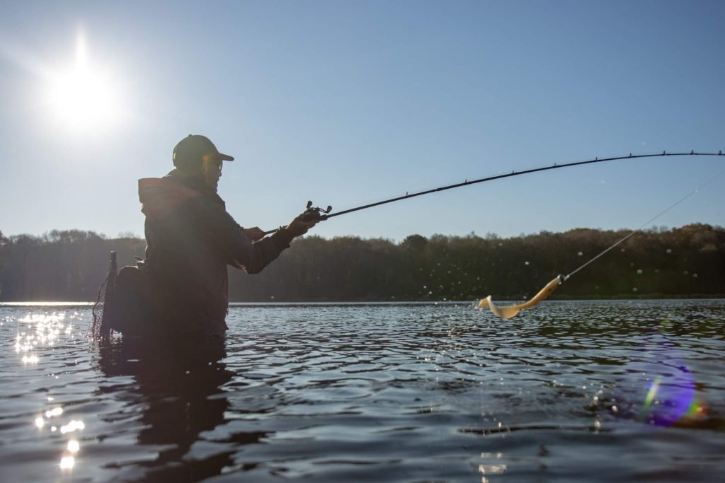 Les pieds dans l'eau en session de pêche au leurre